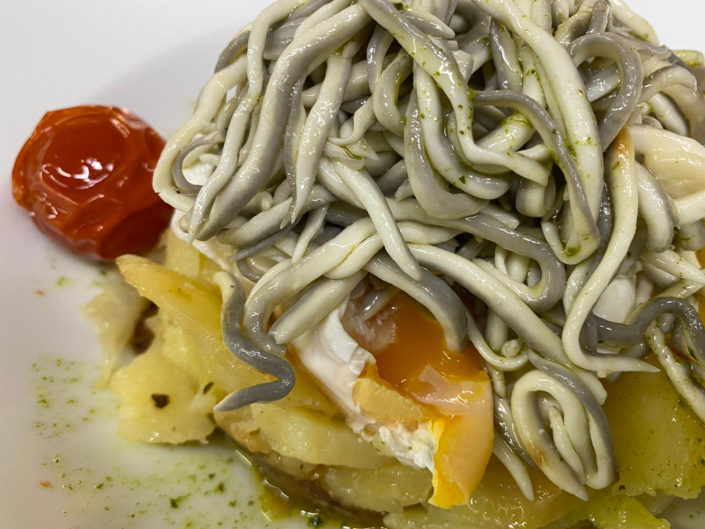 Huevos poche con gulas al ajo morado